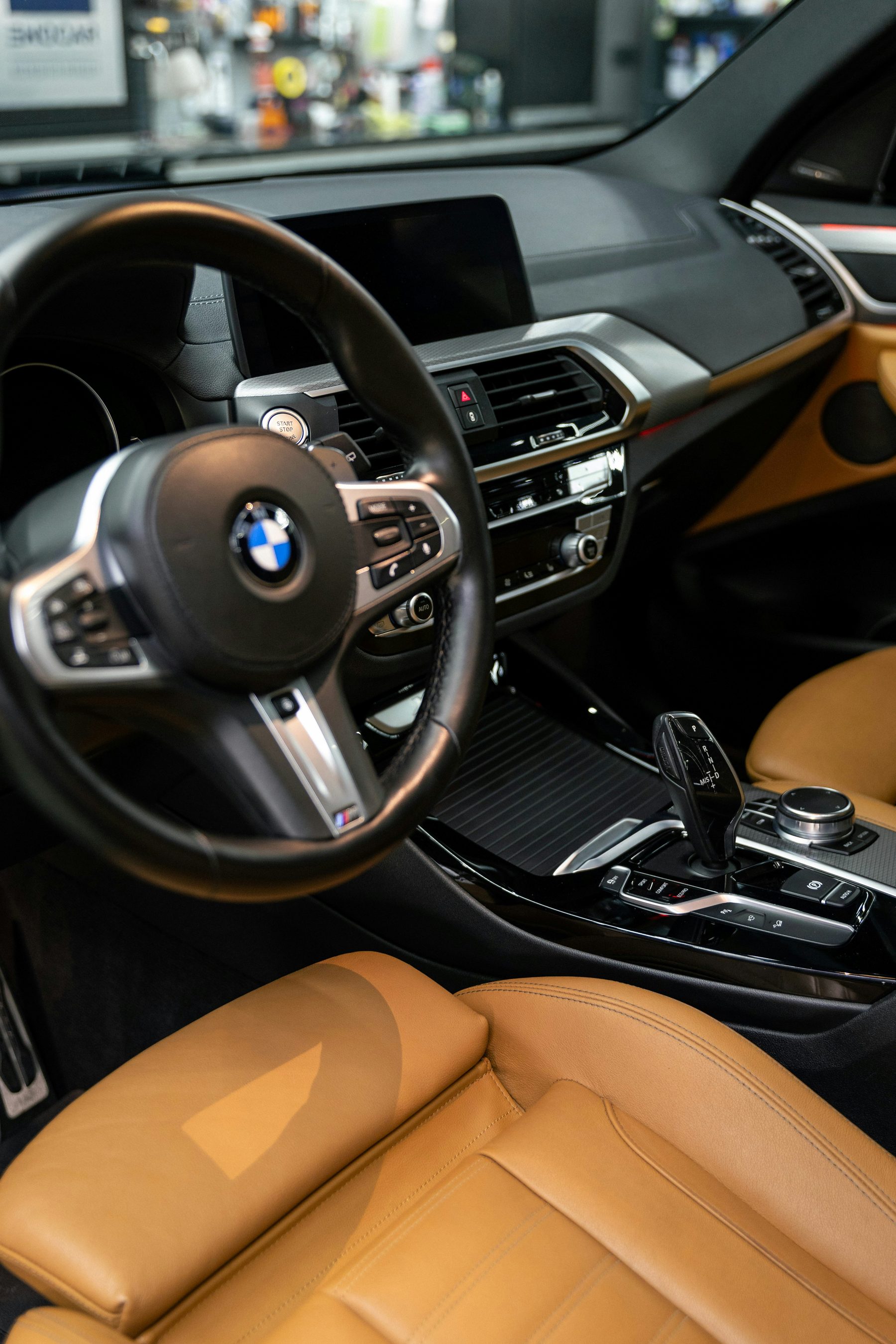 Gereinigd BMW-interieur met cognackleurige lederen stoelen en zwart dashboard